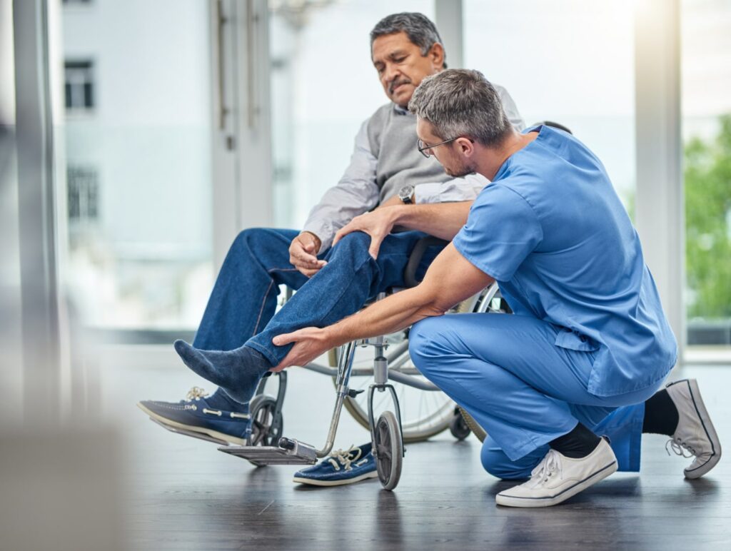 Man in wheelchair receiving help from a doctor