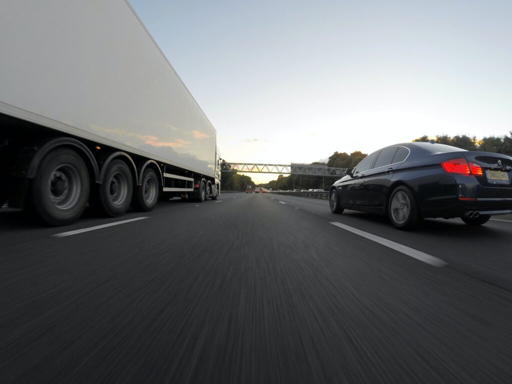 Car driving next to a truck on the highway