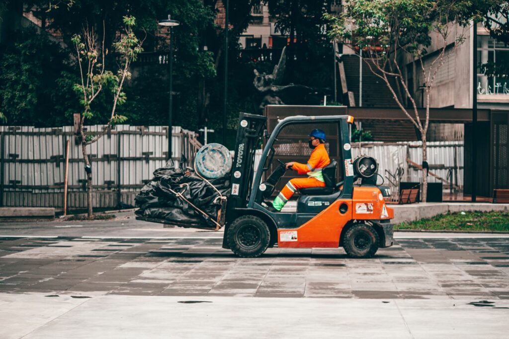 Construction worker in forklift driving on a surface