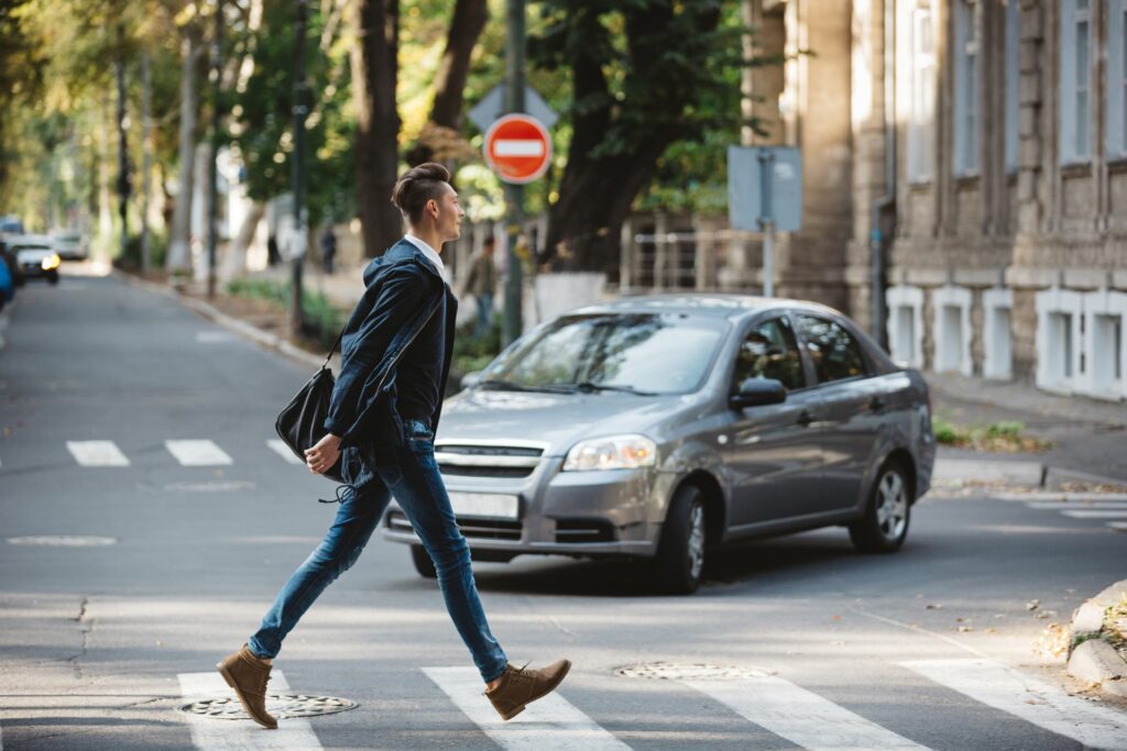 Young man walking across the street